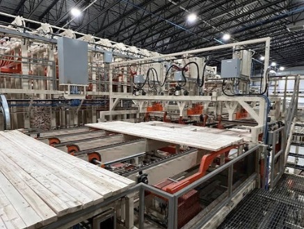 Lumber sorter bins and stacker building a package of boards in a sawmill