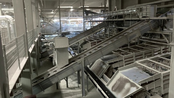 Inclined residual and chip conveyors with chutes inside a sawmill